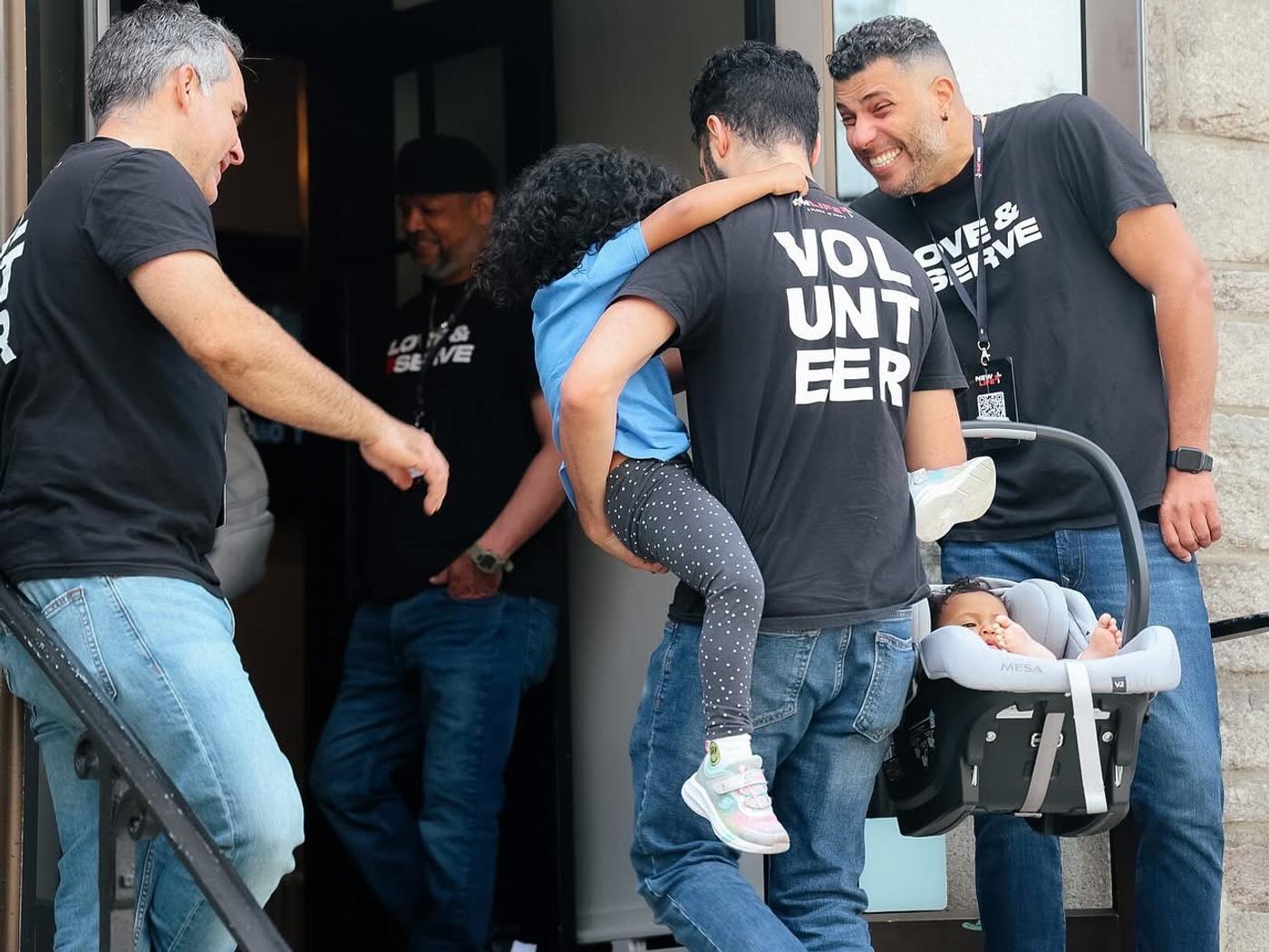 Voluntários recebendo famílias com crianças